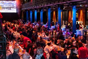 Weihnachtliches Fest in der Hamburger Fischauktionshalle mit rund 450 obdachlosen Menschen sowie Seniorinnen und Senioren, die an festlich gedeckten Tafeln ein Drei-Gang-Menü, Musik und warme Kleidung durch das Projekt „Mehr als eine warme Mahlzeit“ erhalten.