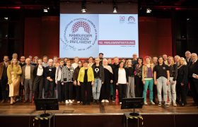 Gruppenfoto der 23 geförderten Projekte sowie der Finanzkommission und des Präsidiums des Hamburger Spendenparlaments bei der 92. Parlamentssitzung.